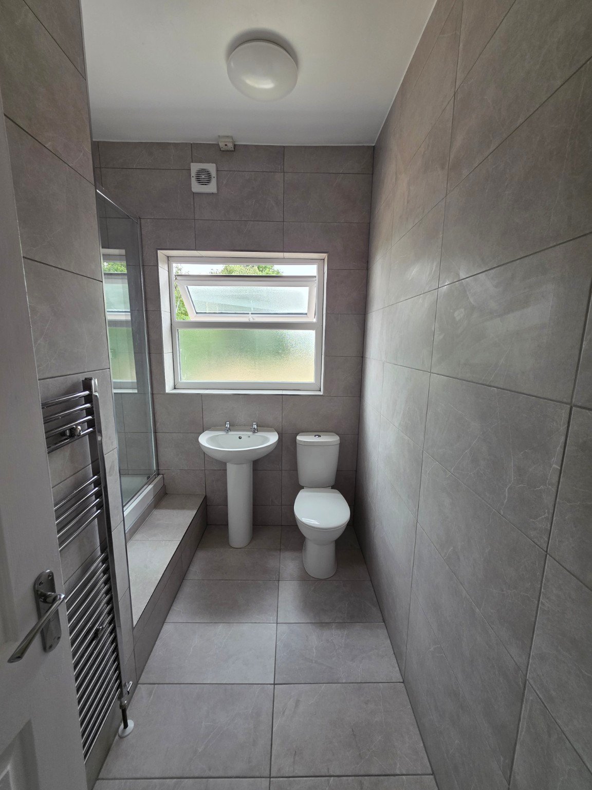 Completed grey tiled bathroom renovation