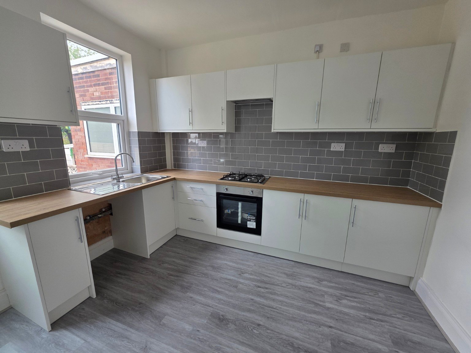 Completed kitchen renovation with new cabinets, tiled splashback and SPC flooring