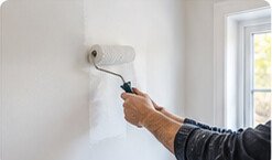Painter decorating a freshly prepared wall